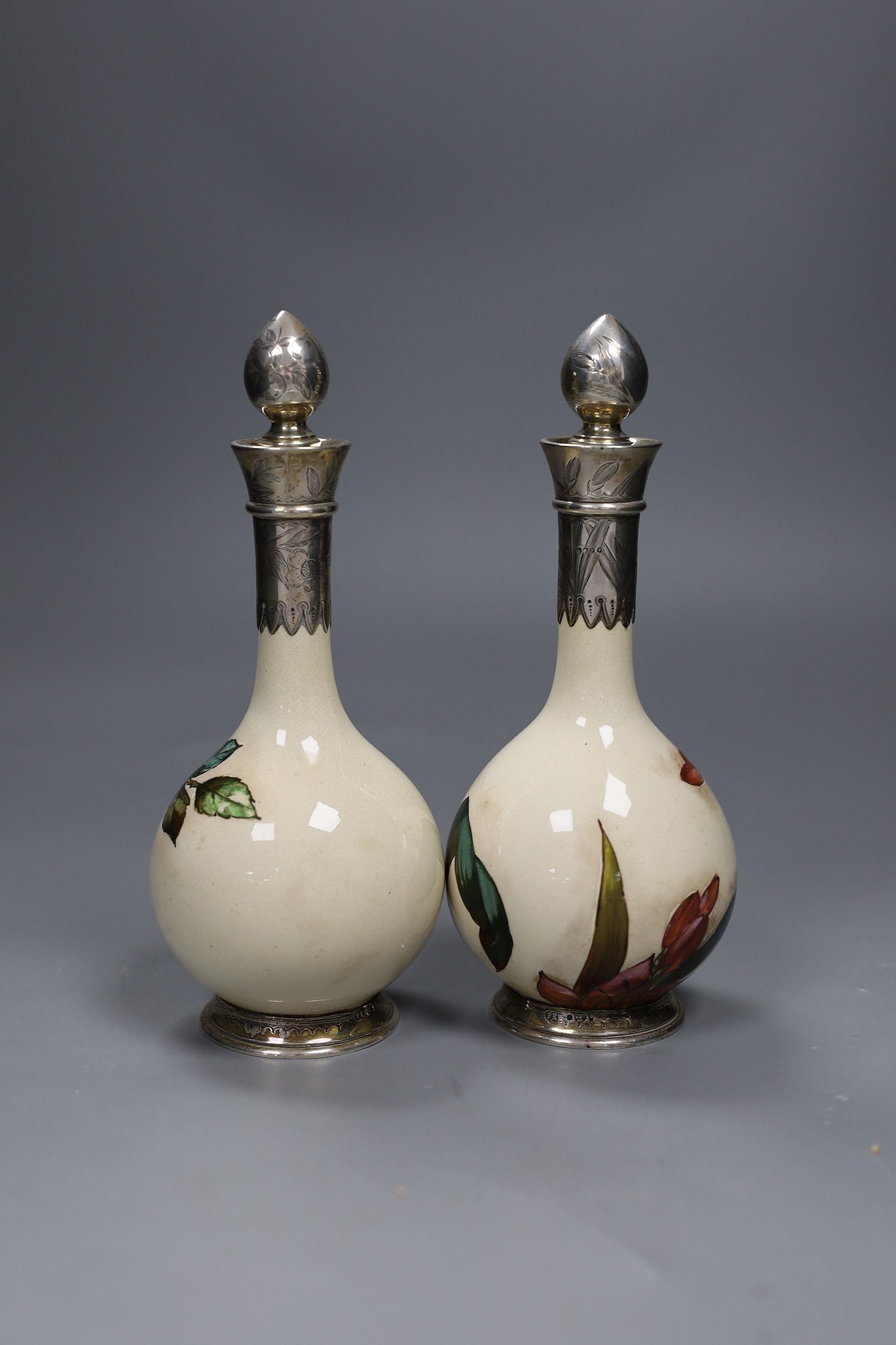 A pair of Victorian silver mounted Art pottery scent bottles, 21.5cms high including stopper